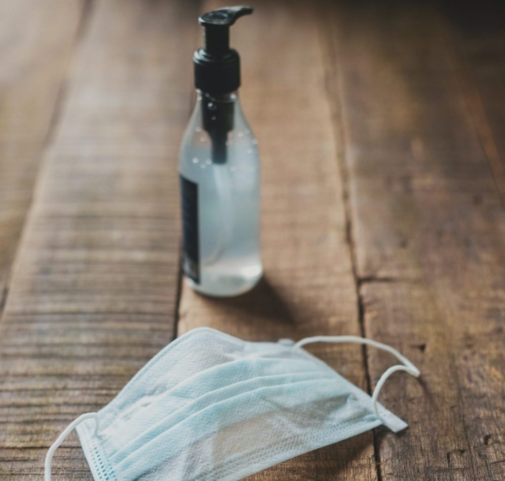 hand sanitizer and mask on floor
