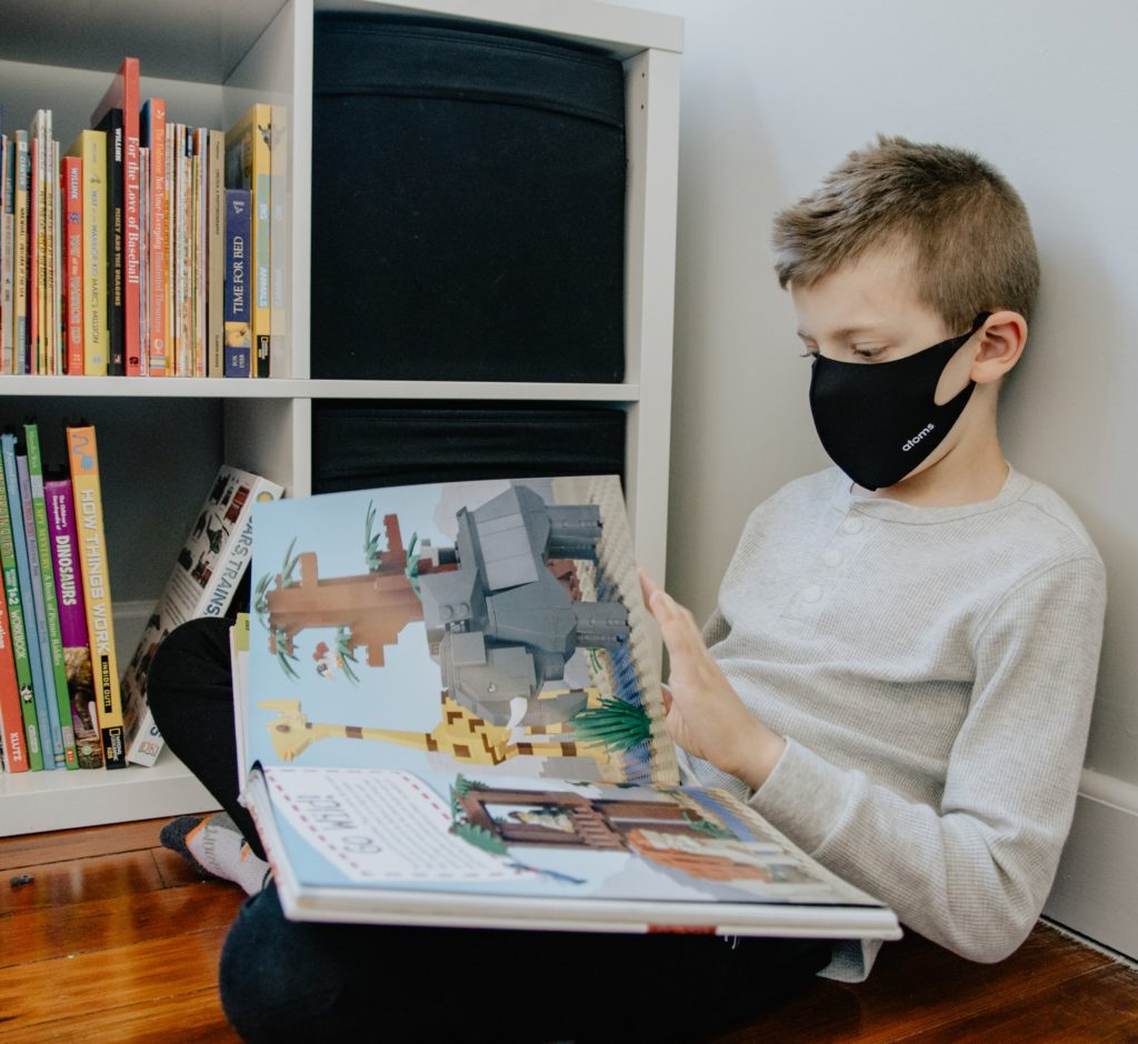 young boy reading a book in class