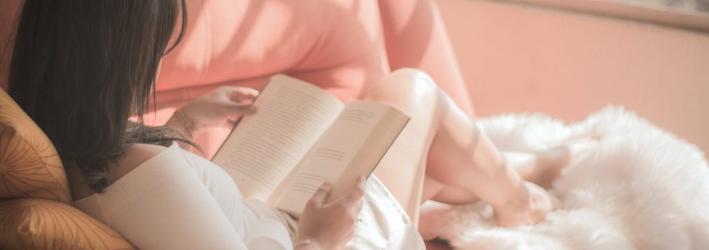 women relaxing on the sofa with a book